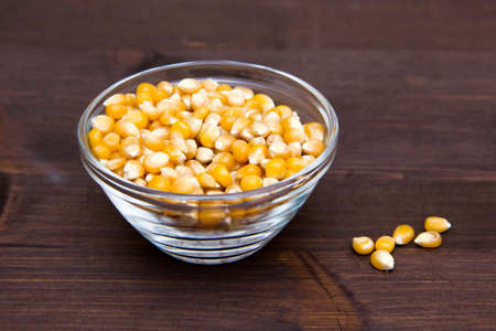 Maize grains dried on bowl on wooden tableの写真素材