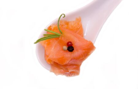Smoked salmon on spoon on white background seen from above and closeの写真素材