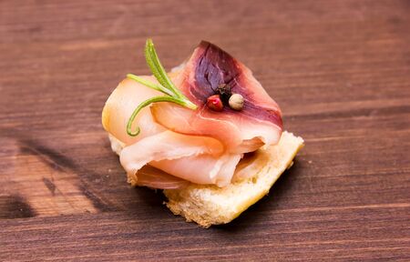 Smoked swordfish on toasted bread on wooden tableの写真素材