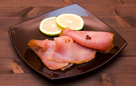 Smoked tuna on black plate on wooden tableの写真素材
