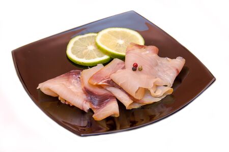 Smoked swordfish on black plate on a white backgroundの写真素材