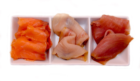Trio of smoked fish on platter on white background seen from aboveの写真素材