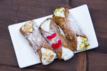 Cannoli with ricotta cheese on wooden table seen from aboveの写真素材