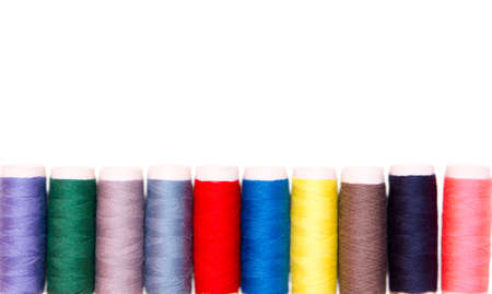 Row of sewing thread in different colors on white background