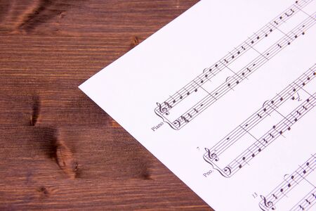 Sheet music for piano on a wooden tableの写真素材