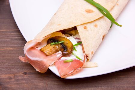 Flatbread with bacon and mushrooms on wood close up view