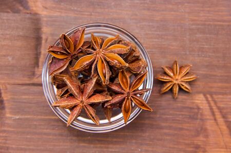 Star anise on bowl on wooden table seen from aboveの写真素材
