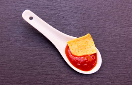 Teaspoon with hot sauce on top in slate from aboveの写真素材