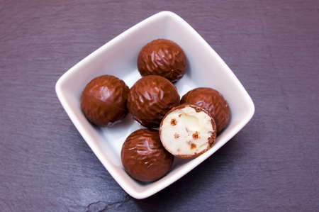 chocolate pralines on a square bowl on slate top top viewsの写真素材