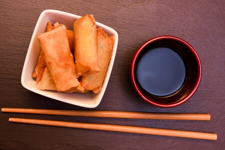 Bowl with spring rolls on a slate top seen from aboveの写真素材