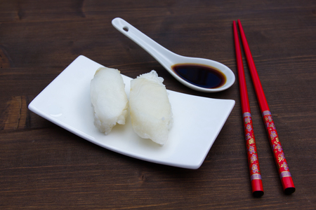 Nigiri with halibut on a wooden tableの写真素材