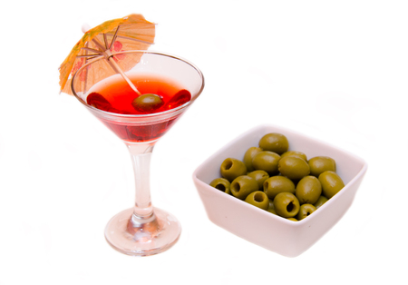 Red cocktail with umbrella and olives on a white backgroundの写真素材