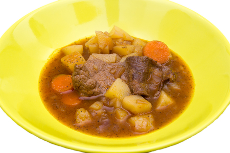 Stewed meat and vegetables on a white background seen close upの写真素材