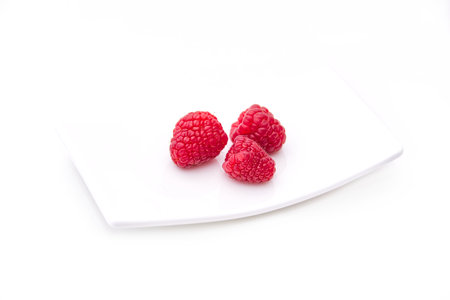 raspberries on tray on a white background