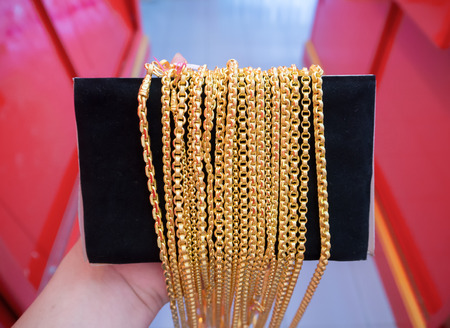 Gold necklaces jewelry hold by handの写真素材