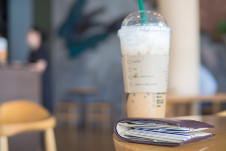Selective focus on wallet style on the table in coffee shop blurry backgroundの写真素材