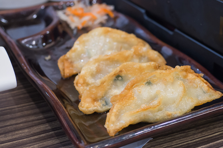 Fried Pork Dumplings Recipe serve in black modern dish with black sauceの写真素材