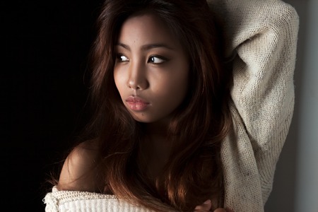 portrait of a girl of Asian appearance, studio photography  black background, knitted jacketの写真素材