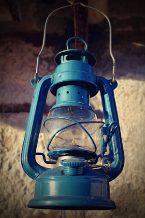 Old blue kerosene lantern hanging on the wallの写真素材