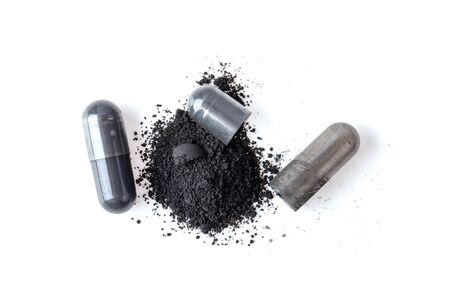 Activated charcoal capsule and powder isolated on white. top viewの写真素材