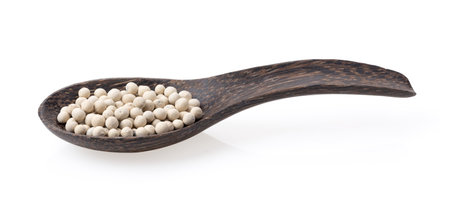 Peppercorn in wood spoon isolated on white backgroundの写真素材