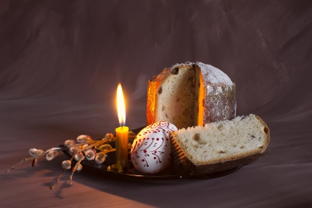 Easter still life with a candle and a cake with sprigs of willowの写真素材