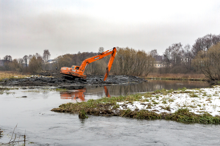 Balashikha, Moscow region, Russia - December, 2017: Excavator removes silt from the bottom of the river Pekhorkaのeditorial素材