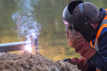 Balashikha, Moscow area, Russia - May 8, 2018: The worker conducts welding of metal designs at construction of the embankment on the river bank of Pekhorkaのeditorial素材