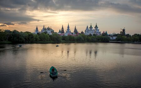 Moscow, Russia - July 21, 2018: A summer landscape on a pond with floating boats in the warm summer eveningのeditorial素材