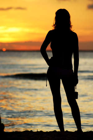Girl watching the sunset on the beachの写真素材