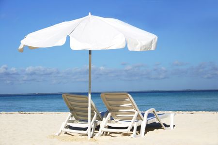 Single white parasol and sun lounger on deserted tropical beachの写真素材