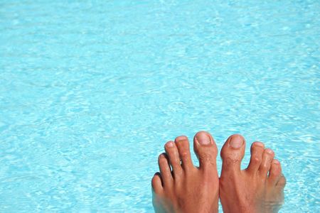 Man's feet with bright blue swimming poo lbackgroundの写真素材