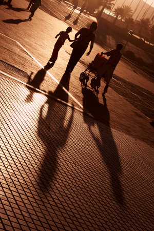 Woman and two children walking at sunsetの写真素材
