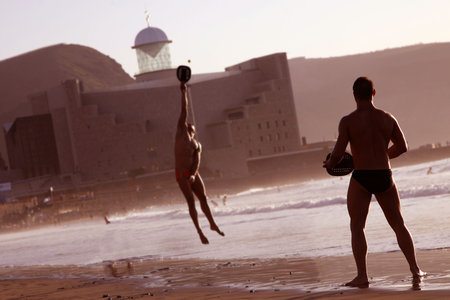 Two men playing beach tennis on the beachの写真素材