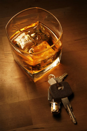 Whiskey in light pool on brown table with car keysの写真素材