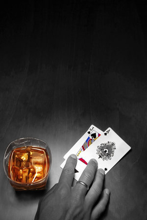Poker player in mono with cards and whiskey in colorのeditorial素材