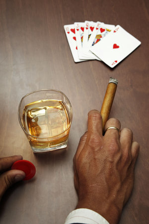 Poker player with cards cigar and whiskey のeditorial素材