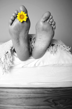 Mono feet at the end of the bed with color flowerの写真素材