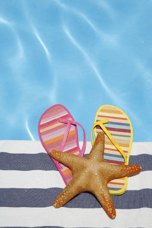 Odd summer shoes by pool with starfishの写真素材