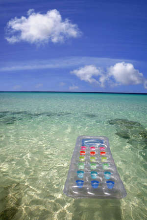 Airbed floating in green lagoon water with blue sky