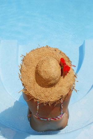 Woman sunbathing by bright poolの写真素材