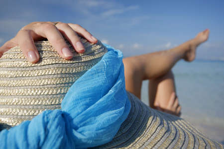 One of a large series. Pretty girl in big straw hat on a tropical beach.の写真素材
