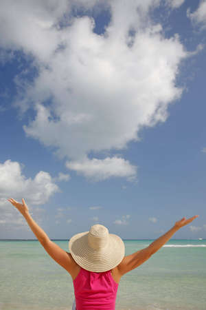 Woman on the beach with dramatic sky behindの写真素材