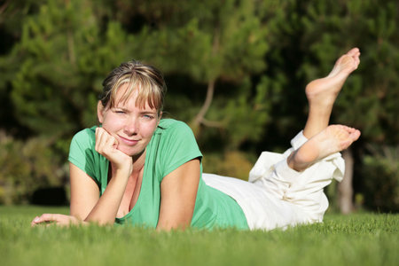 Woman relaxing on a lawn with a nice defocused backgroundの写真素材