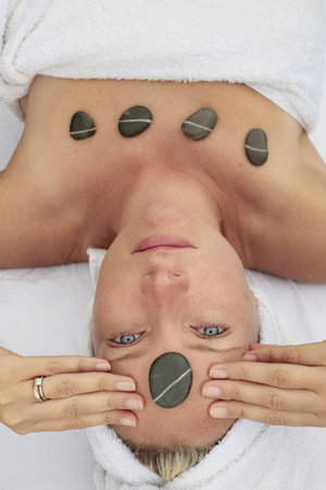 Woman at a spa with stone on her forehead