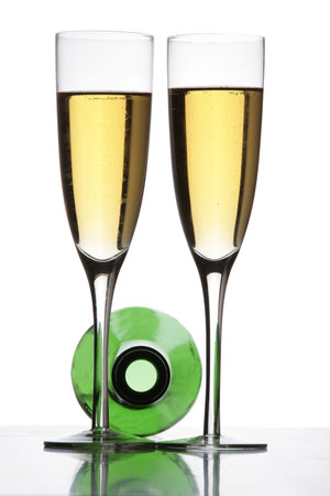 Two champagne glasses and a bottle in silhouetteの写真素材