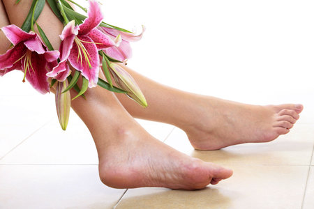 Womans legs and pink lilliy flowers backlitの写真素材