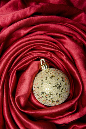 Gold mosaic Christmas bauble on a red satin backgroundの写真素材