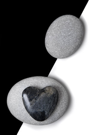 Stone heart and white pebbles on a split backgroundの写真素材