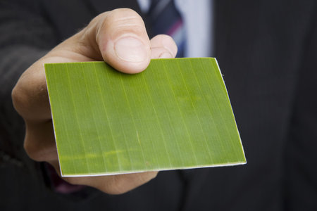 Man giving out a green business cardの写真素材